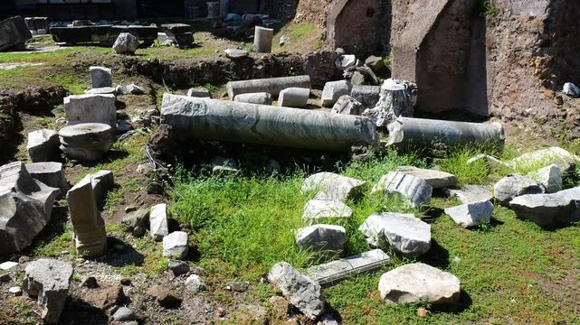 scattered marble blocks fallen fluted column rest amid grass excavated earth quiet disorder nature return define ancient architectural ruins foro di cesare rome italy roman empire emperor 