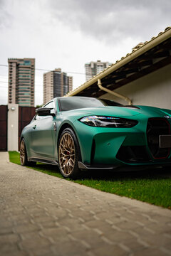 Matte green BMW M4 CS front low angle view, Luxury sports coupe in urban setting