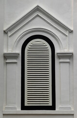 Arched Louvered Window on White Classical Building Facade