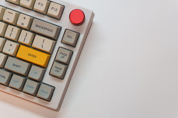 White mechanical keyboard with bright Enter key on white background, minimalism, keyboard buttons....