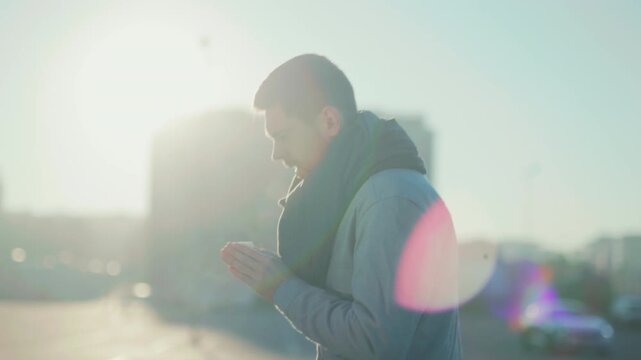 Man pauses thoughtfully, An individual in winter attire pauses to reflect while observing glowing city skyline