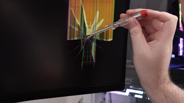 A technician's hand with a screwdriver inspects a shattered computer monitor, a key concept for hardware failure, damage diagnostics, and modern electronic repair work
