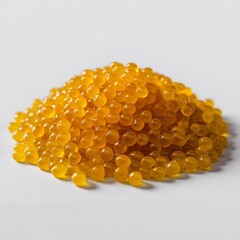 Bright yellow caviar scattered in a pile on a white background