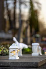 Lit burning candle at night on black stone monument in cemetery. Memory of the deceased. Expression of love
