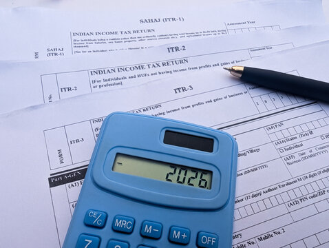 Indian income tax return ITR 1,2,3 forms with blue calculator showing 2026 and black pen photo stock photo