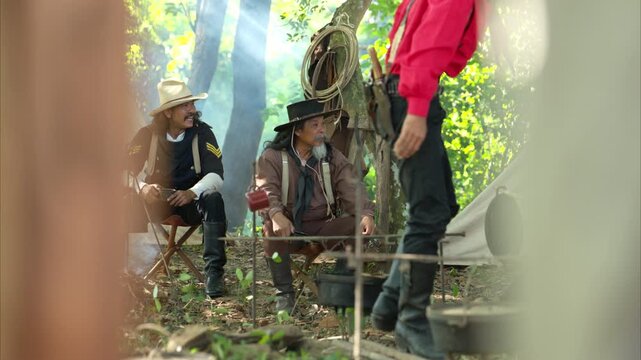 Cowboys preparing food at a campfire, roasting meat together in a warm and rustic outdoor setting