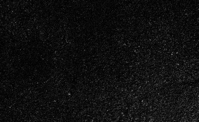 Close-up of dark black granular texture with fine rough surface and subtle highlights. Abstract background ideal for design, overlays, industrial themes, and modern layouts.