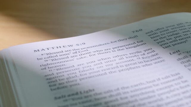 Macro video of Gospel of Matthew pages turning in a modern Bible. Clean typography, soft lighting. Ideal for religious, spiritual, or christian educational content. 4K close up slide left