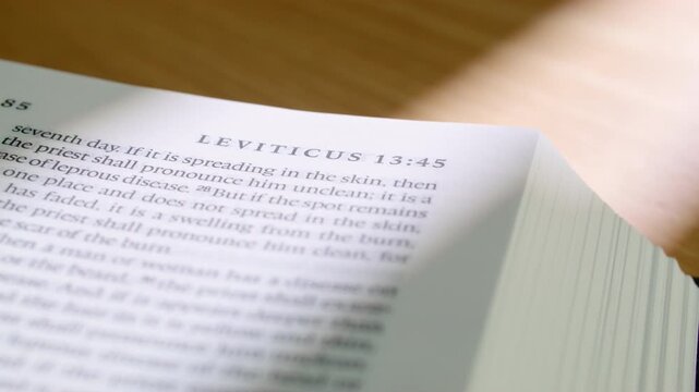 Macro video of modern Bible - Leviticus book chapter 11 with pages turning. Clean typography, soft lighting. Ideal for Christian, spiritual, or educational content. 4K close up slide right motion