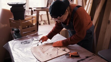 Female professional restorer working on vintage wooden furniture in workshop