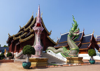 Obraz premium Ornate Wat Ban Den temple in Thailand with dragon statues and intricate architecture under a clear sky.