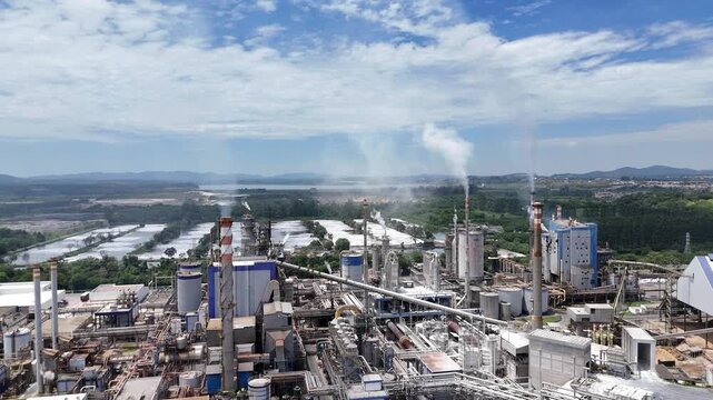 Vis&atilde;o a&eacute;rea de f&aacute;brica de papel e celulose revela caldeiras, chamin&eacute;s e sistemas industriais operando de forma integrada em uma grande planta de produ&ccedil;&atilde;o.