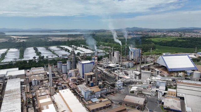 Vista a&eacute;rea da ind&uacute;stria de papel e celulose destaca chamin&eacute;s ativas, caldeiras e uma planta fabril de grande porte, representando a for&ccedil;a da ind&uacute;stria de base e da produ&ccedil;&atilde;o industrial moderna.