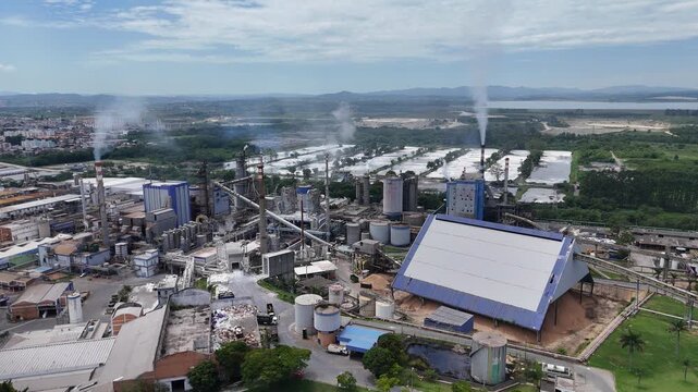 Vis&atilde;o a&eacute;rea mostra ind&uacute;stria de papel e celulose em funcionamento, com caldeiras e chamin&eacute;s dominando a paisagem e revelando a escala e a complexidade da produ&ccedil;&atilde;o industrial cont&iacute;nua.