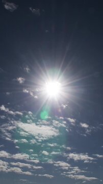 Clouds passing in a blue sky with the sun. Time Lapse. 4K Vertical