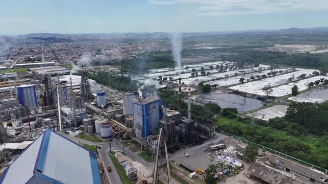 &Aacute;rea industrial de papel e celulose com infraestrutura pesada, destacando caldeiras, chamin&eacute;s e a rela&ccedil;&atilde;o entre produ&ccedil;&atilde;o industrial e meio ambiente.