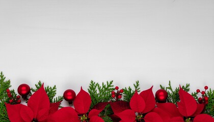 Minimal Christmas background with red poinsettia flowers, evergreen foliage, red berries and ornaments on white wooden surface with copy space.