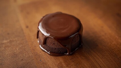 A realistic mini chocolate cake with chocolate glaze, simple design, placed on a wooden table, natural light, high detail, professional food photography