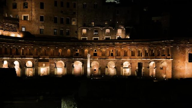 night time trajan market gently curving brick facade arches niches medieval buildings rise behind trajan's wide view rome italy roman empire emperor 