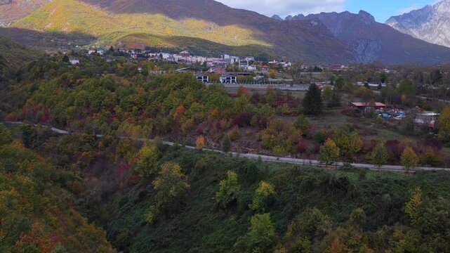 Autumnal aerial video of Bajram Curri showing colourful forests, rural homes, farmland and the city core, all resting beneath the towering peaks of the Albanian Alps.
