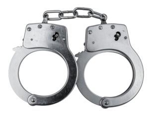 Close-up of shiny, silver metal handcuffs, lying flat against a plain, dark background