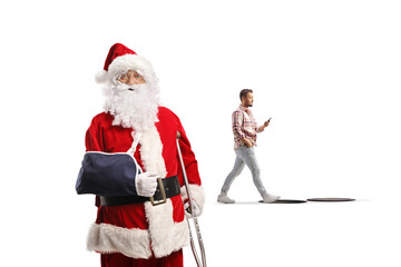 Santa Claus with a broken arm looking at a distracted man about to fall into an open manhole