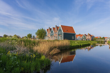 Picturesque historic street in Volendam, Netherlands. Traditional brick houses, clean paved paths and authentic old harbor atmosphere