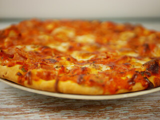 Fresh Pizza on Plate with Shallow Depth of Field Highlighting Toppings Crust Texture and Cozy Dining Atmosphere