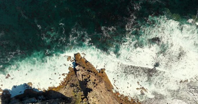 Majestic Aerial top down view of Ocean waves in slow motion, Cape of Good Hope in South Africa. Powerful turquoise surf over the rocky coastal shoreline. Ideal for cinematic travel and nature visuals