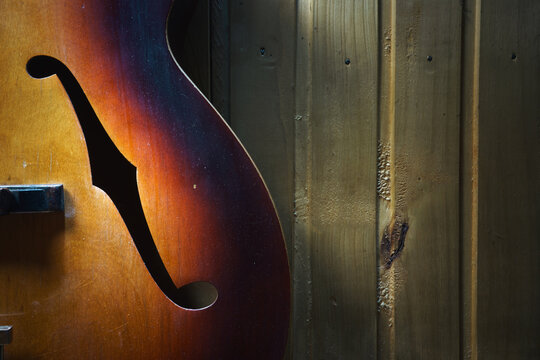 Details of an old jazz guitar on a wooden wall