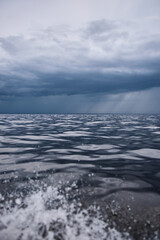 Sailing regatta in the Gulf of Finland in heavily rain, few sailing yachts competing in a race, splashing water from under the boats, teamwork, board the boat