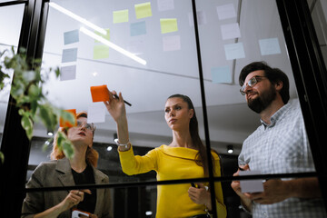 Creative brainstorming session in an office environment with team members collaborating on sticky notes