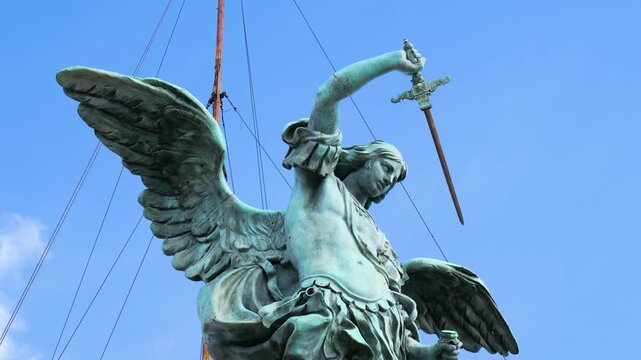 patinated bronze winged statue atop castel sant angelo rome powerful angel raising sword taut cables frame sant'angelo up close italy roman empire emperor 