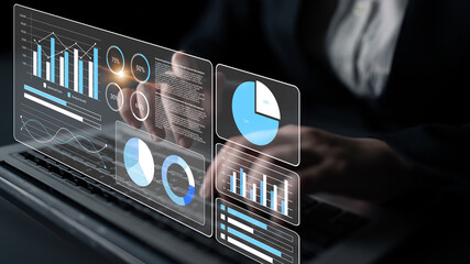 A professional analyzes data through modern graphs and charts on a laptop screen in a dark office environment, showcasing advanced analytics and business insights. Gantry
