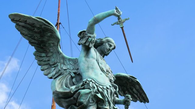 powerful bronze archangel michael statue crowning castel sant angelo rome winged figure mid motion clear blue sky defines sant'angelo up close italy roman empire emperor 