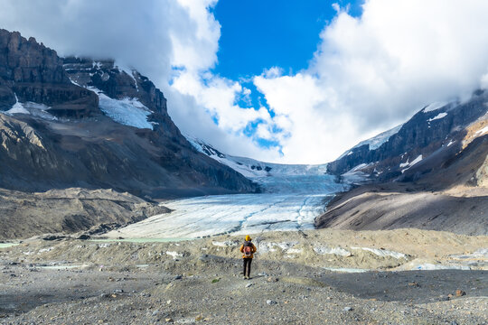 Hiker contemplating athabasca glacier in jasper national park, canadian rockies