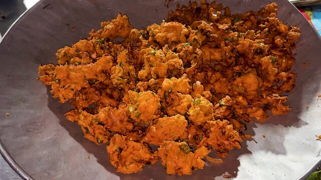 traditional indian onion pakora in metal bowl at street shop