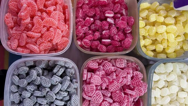 multicolor sugar candies organized in plastic containers at street shop for sale