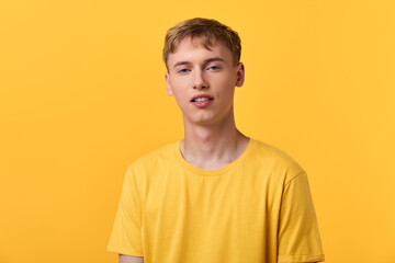 Yellow shirt worn by a young man against a bright background in a minimal studio setting,...