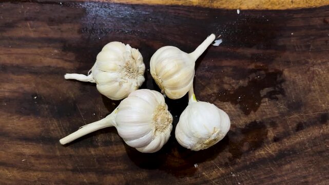 fresh whole garlic bulbs on dark wood cutting board