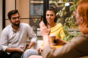Group of friends discussing ideas in a modern workspace during an afternoon meeting