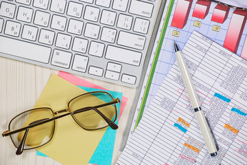 Business and accounting supplies arranged in a composition on an office desk. Top view.