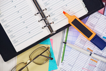 Business and accounting supplies arranged in a composition on an office desk. Top view.