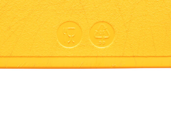 A border of a used yellow chopping board with recycled symbols on white