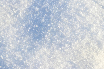 Obraz premium Texture of fresh white snow with shadow on sunny winter day close-up with natural lighting
