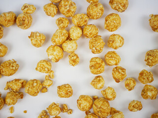 Closeup top view of caramel popcorn balls filling the frame on white surface, detailed crunchy texture of sweet snack for packaging, posters and food background