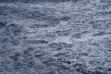 blue water sea waves in the ocean From above aerial view of grey gray ocean water with foam splashes and foam for abstract natural background and texture.