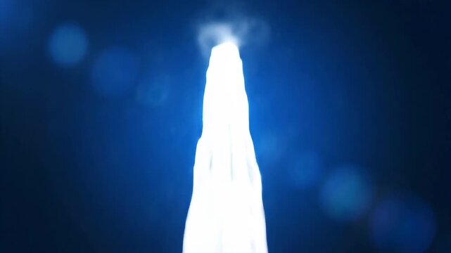 Dynamic Water Jet Stream Against Dark Blue Background with Bokeh Effect.