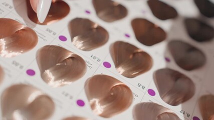 womans hand touching copper color swatches, closeup of manicured nail selecting metallic heart shaped samples for salon consultation, warm bronze and auburn hues, glossy finish and subtle shimmer,