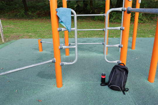Calisthenics equipment in outdoor park with backpack and water bottle